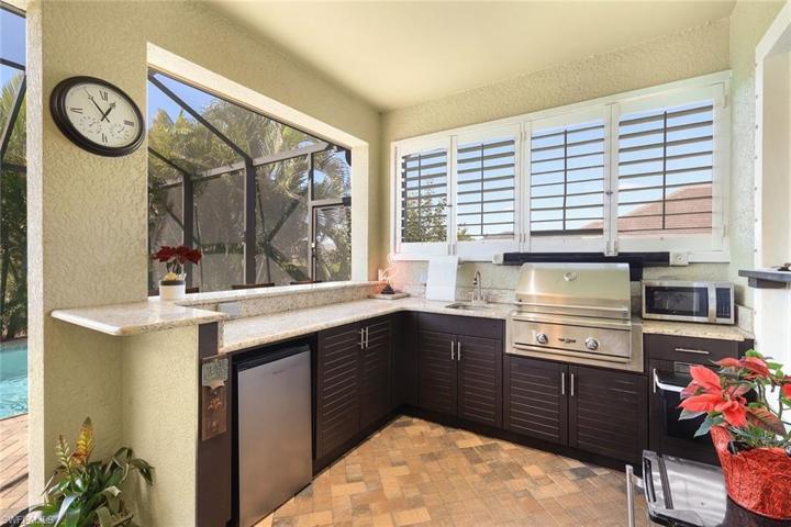Custom outdoor kitchen with built-in natural gas grill, fridge, and sink.