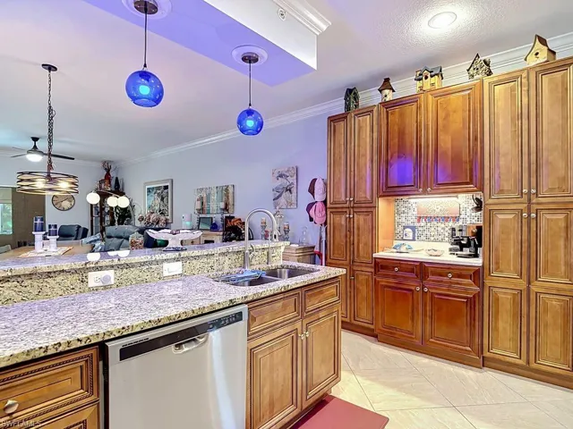 Kitchen featuring light wood cabinetry, granite-style countertops, and a built-in beverage station with a mosaic tile backsplash