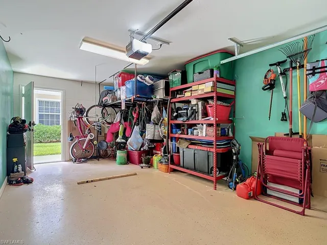 Spacious garage featuring an epoxy-coated floor, overhead lighting, and an automatic garage door opener