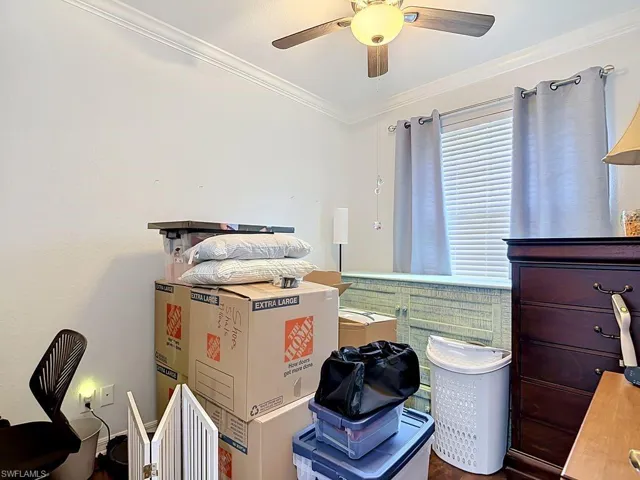White walls featuring crown molding and wood-finish flooring