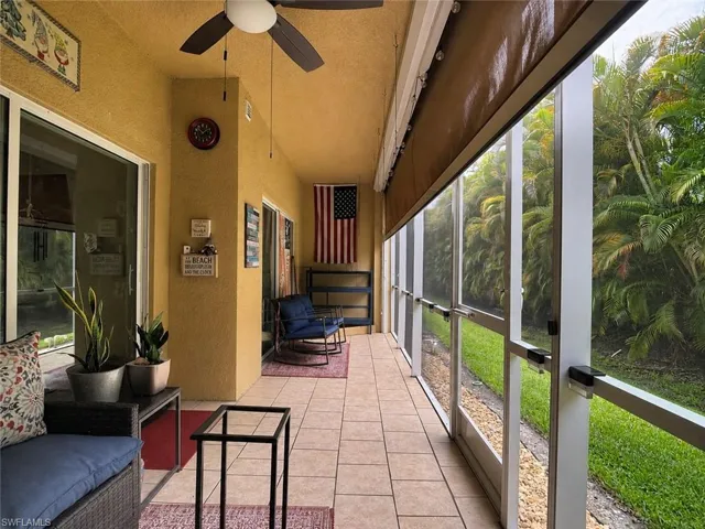 Private View. Screened-in outdoor living space featuring ceramic tile flooring, a ceiling fan, and sliding glass doors, Retractable Hurricane Shades.