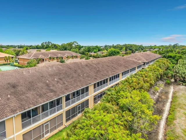 Multi-story building featuring tile roofing and screened balconies/patios
