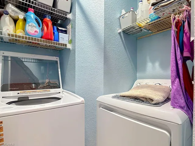 Dedicated laundry area with dual appliances and wire shelving