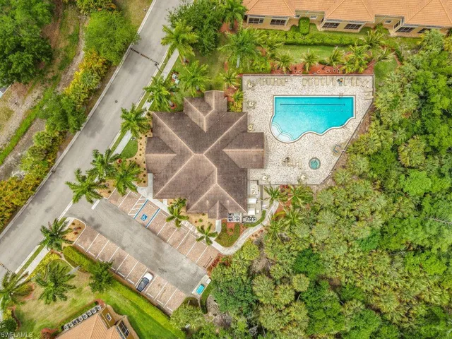 Community recreation area featuring a clubhouse with a multi-gabled roof, a freeform swimming pool, and an integrated spa
