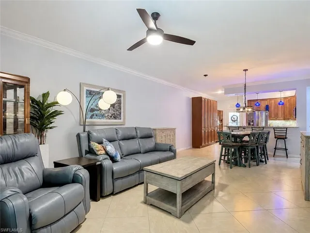 Open concept living area featuring tile flooring, crown molding, a ceiling fan, and recessed lighting