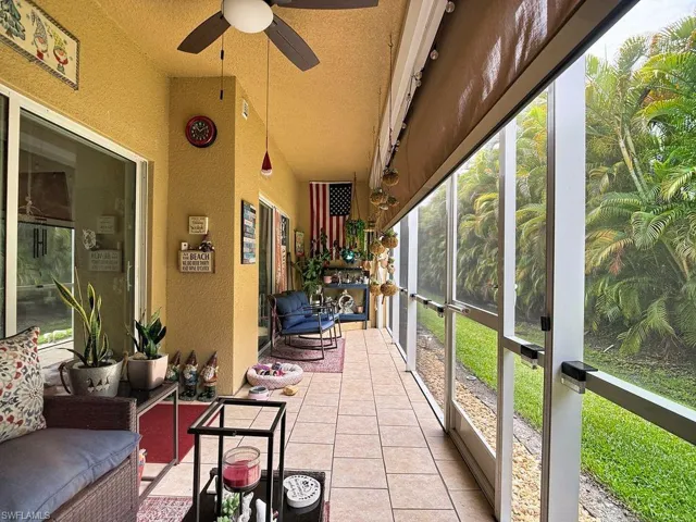 Screened patio featuring tile flooring and a ceiling fan