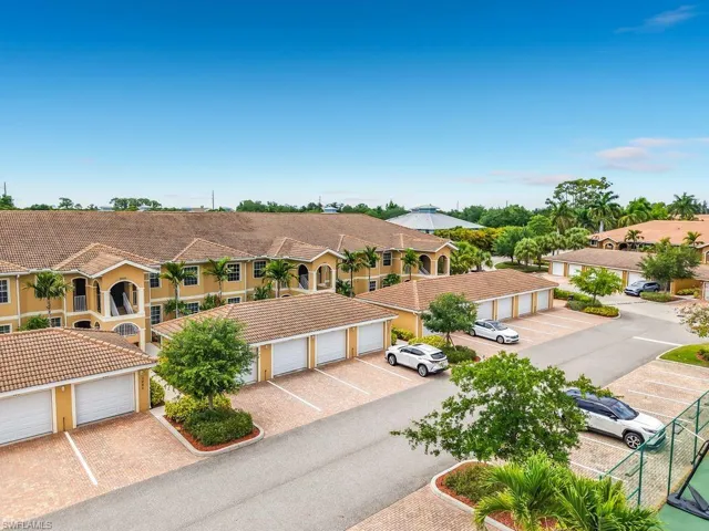 Residential community featuring multi-story buildings with tile roofs and stucco exteriors