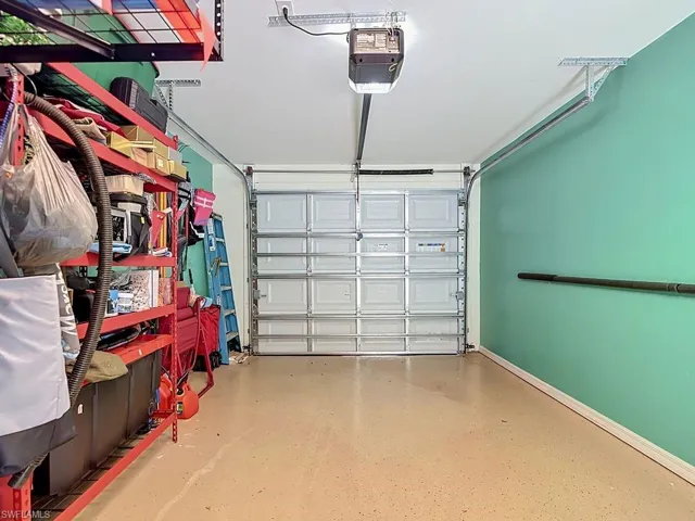 Garage interior featuring a sectional overhead door, a light-colored epoxy floor, and painted walls