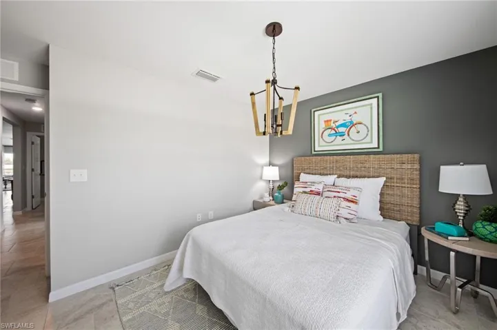 Interior room featuring a contemporary chandelier, a contrasting accent wall, and tiled flooring