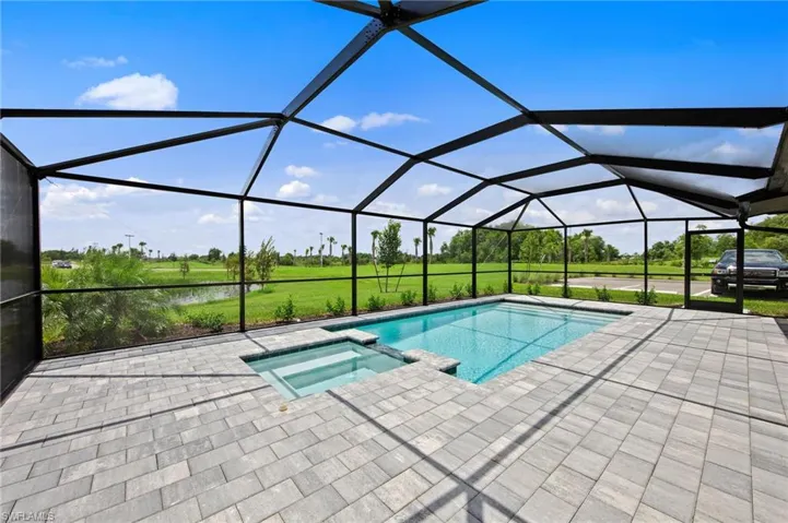 Screened lanai featuring a rectangular pool with an integrated spa