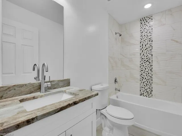 Full bathroom featuring vanity, shower / tub combination, and recessed lighting