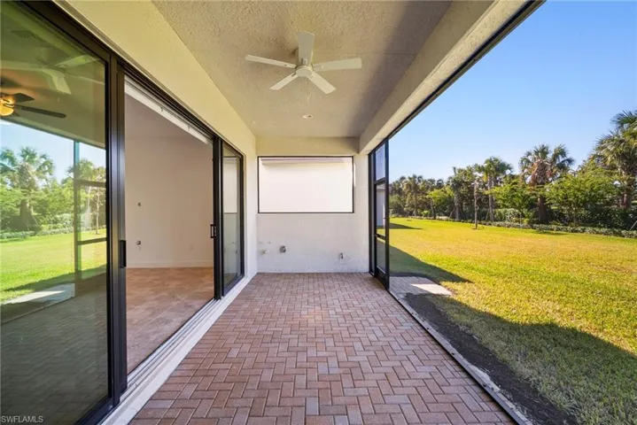 Unfurnished sunroom featuring ceiling fan and a patio area