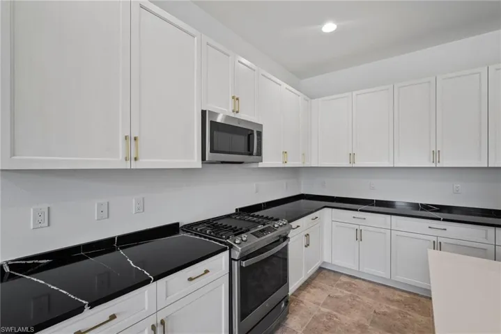 Kitchen with stainless steel appliances and white cabinetry