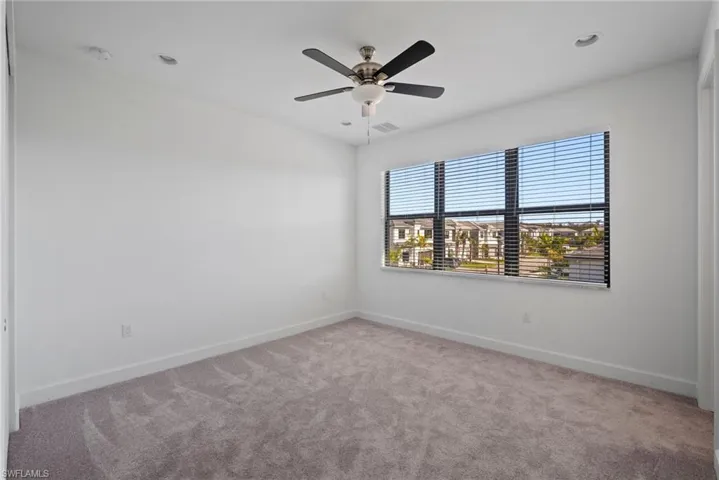 Empty room featuring light colored carpet, ceiling fan, and recessed lighting