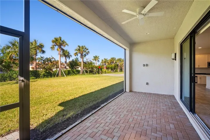 Unfurnished sunroom with a patio area and a ceiling fan