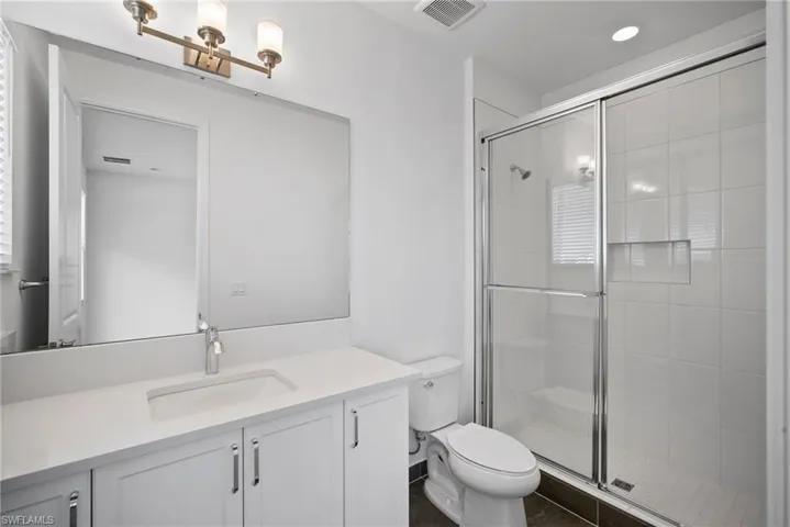 Full bath featuring vanity, a shower stall, and recessed lighting
