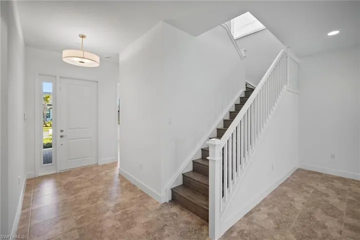 Foyer entrance with stairway and baseboards