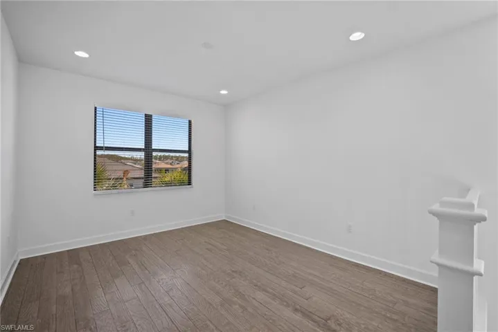 Empty room with wood finished floors and recessed lighting