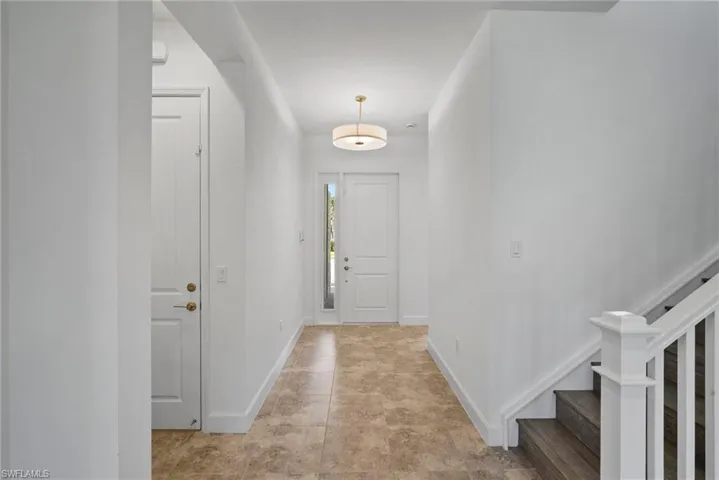 Foyer with stairs and light tile patterned floors