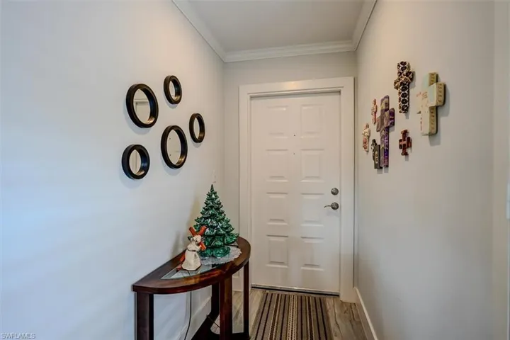 Doorway featuring ornamental molding and hardwood / wood-style flooring