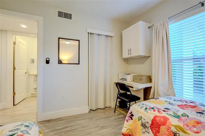 Bedroom with multiple windows and light hardwood / wood-style floors