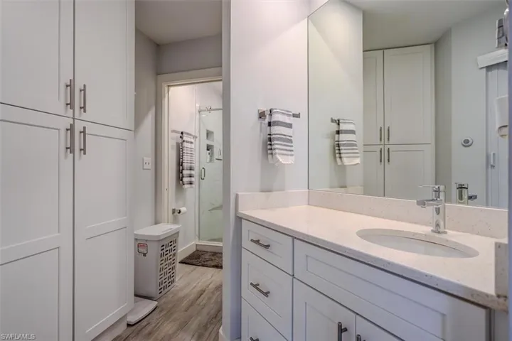 Bathroom featuring hardwood / wood-style flooring, vanity, and a shower with door