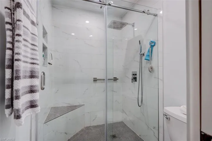 Bathroom featuring toilet and a shower with door