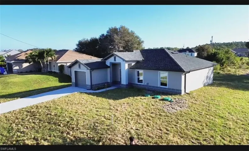 Ranch-style home with a front lawn and a garage