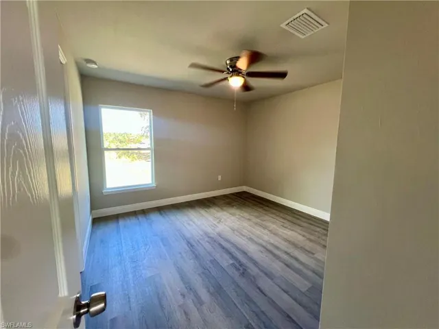 Spare room with hardwood / wood-style flooring and ceiling fan