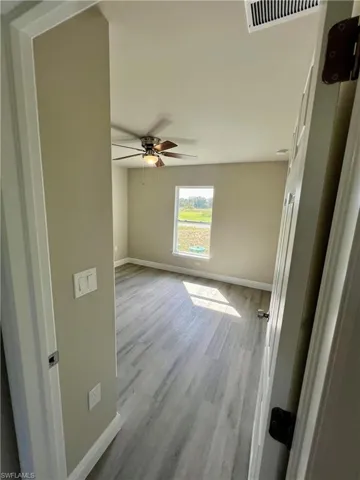 Unfurnished room with light hardwood / wood-style floors and ceiling fan