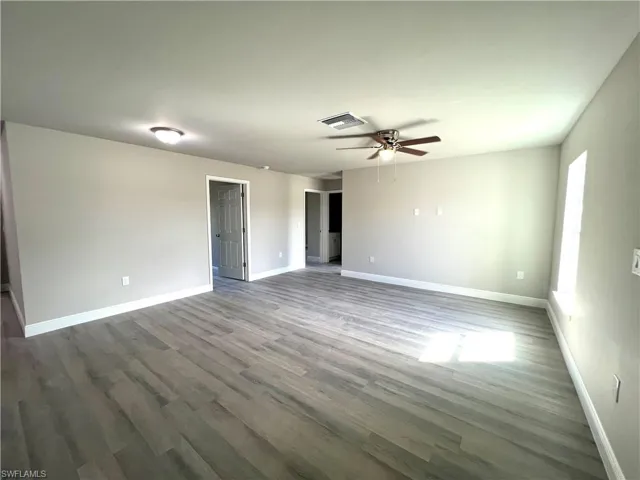 Unfurnished room featuring dark hardwood / wood-style floors and ceiling fan