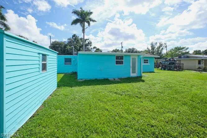 Back of property with a lawn