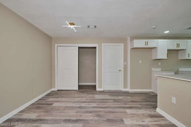 Kitchen with white cabinets and light hardwood / wood-style flooring
