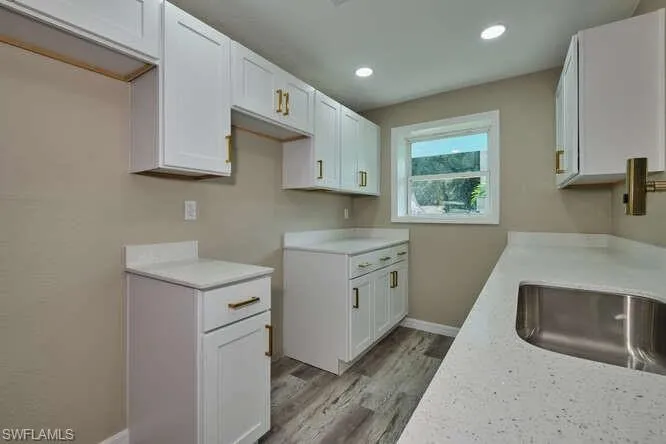 Kitchen with white cabinets and light wood-type flooring