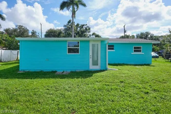 Back of property with a lawn