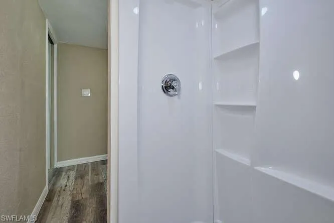 Bathroom with walk in shower and hardwood / wood-style flooring
