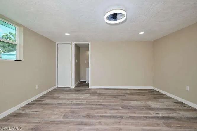 Spare room featuring a textured ceiling and light hardwood / wood-style floors