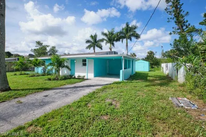 View of front of property featuring a carport and a front yard