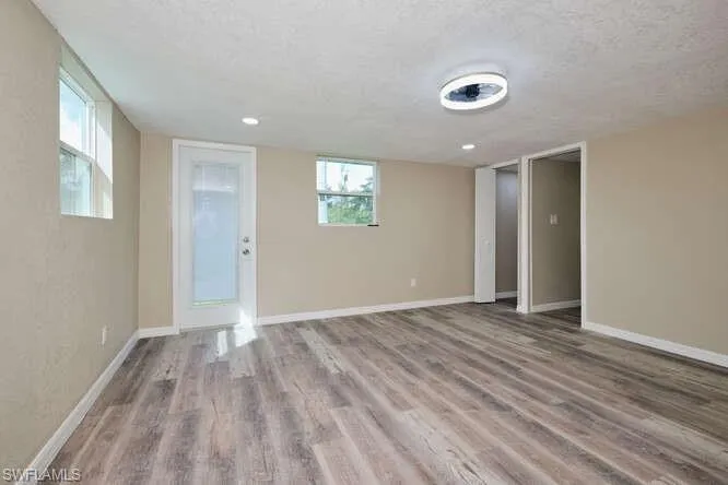 Empty room with wood-type flooring and a textured ceiling