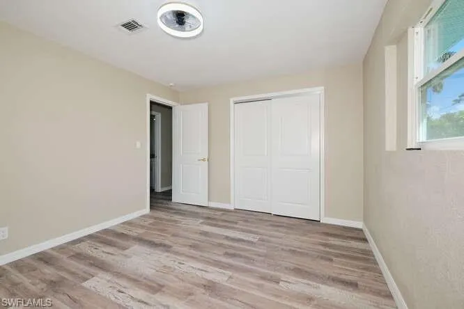 Unfurnished bedroom featuring light wood-type flooring and a closet