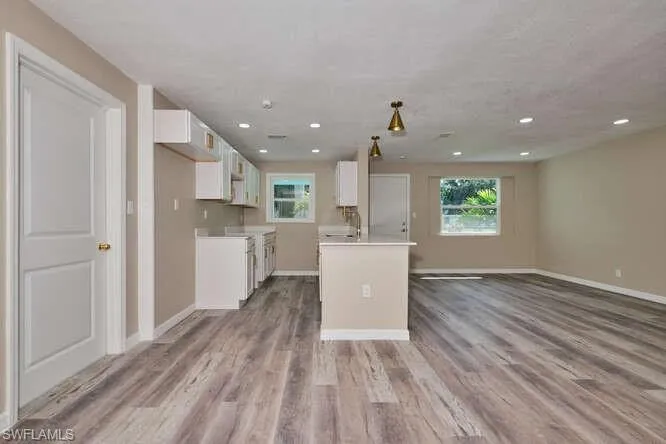 Kitchen with white cabinets, light wood-type flooring, and a center island