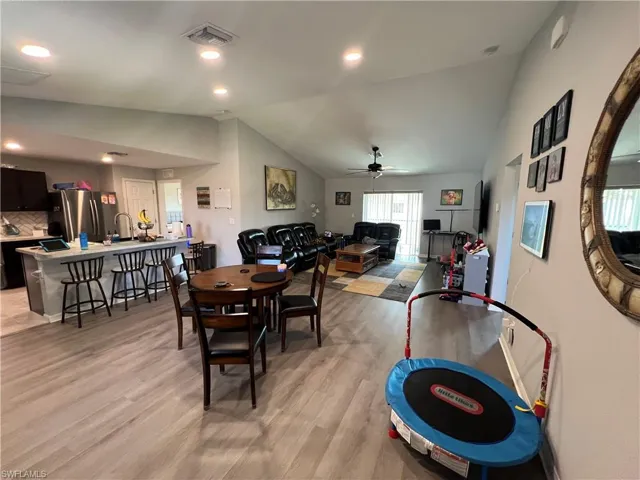 Dining room with vaulted ceiling, ceiling fan, light wood-type flooring, and recessed lighting