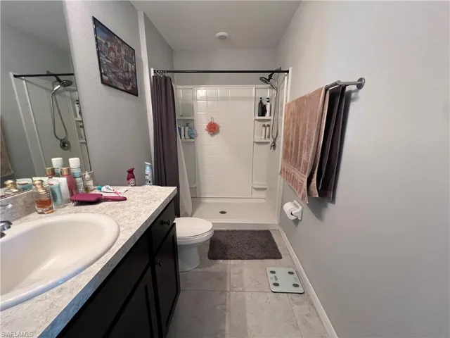 Full bathroom featuring a shower stall and vanity