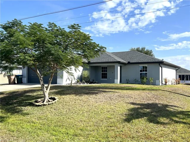 View of front of property featuring stucco siding, a front lawn, roof with shingles, and an attached garage