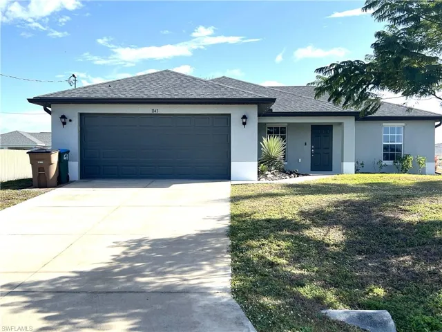 Ranch-style house with stucco siding, roof with shingles, driveway, an attached garage, and a front lawn