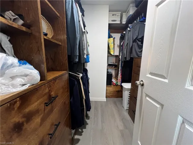 Spacious closet with light wood finished floors