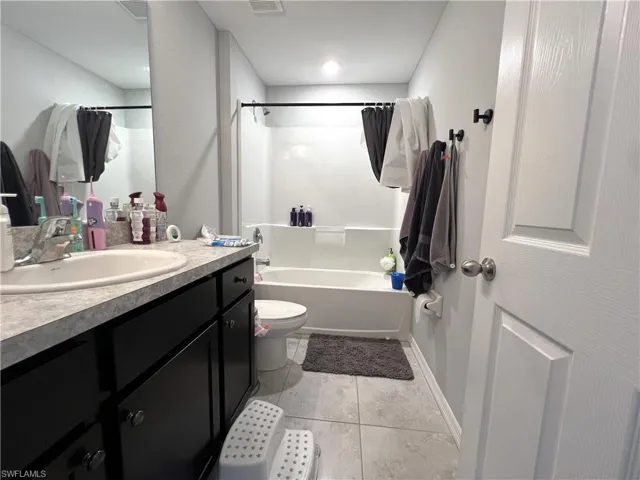 Full bathroom with vanity,  shower combination, and light tile patterned floors