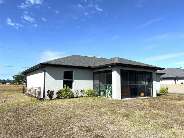 Back of property with stucco siding, a shingled roof, and a sunroom