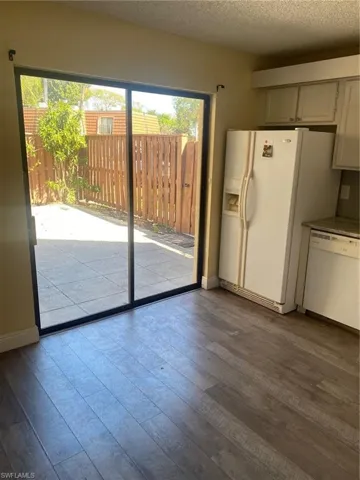 Kitchen featuring dishwasher, vinyl flooring, and fridge.