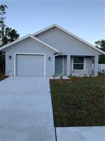 View of front of home featuring a porch, a garage, and a front lawn
